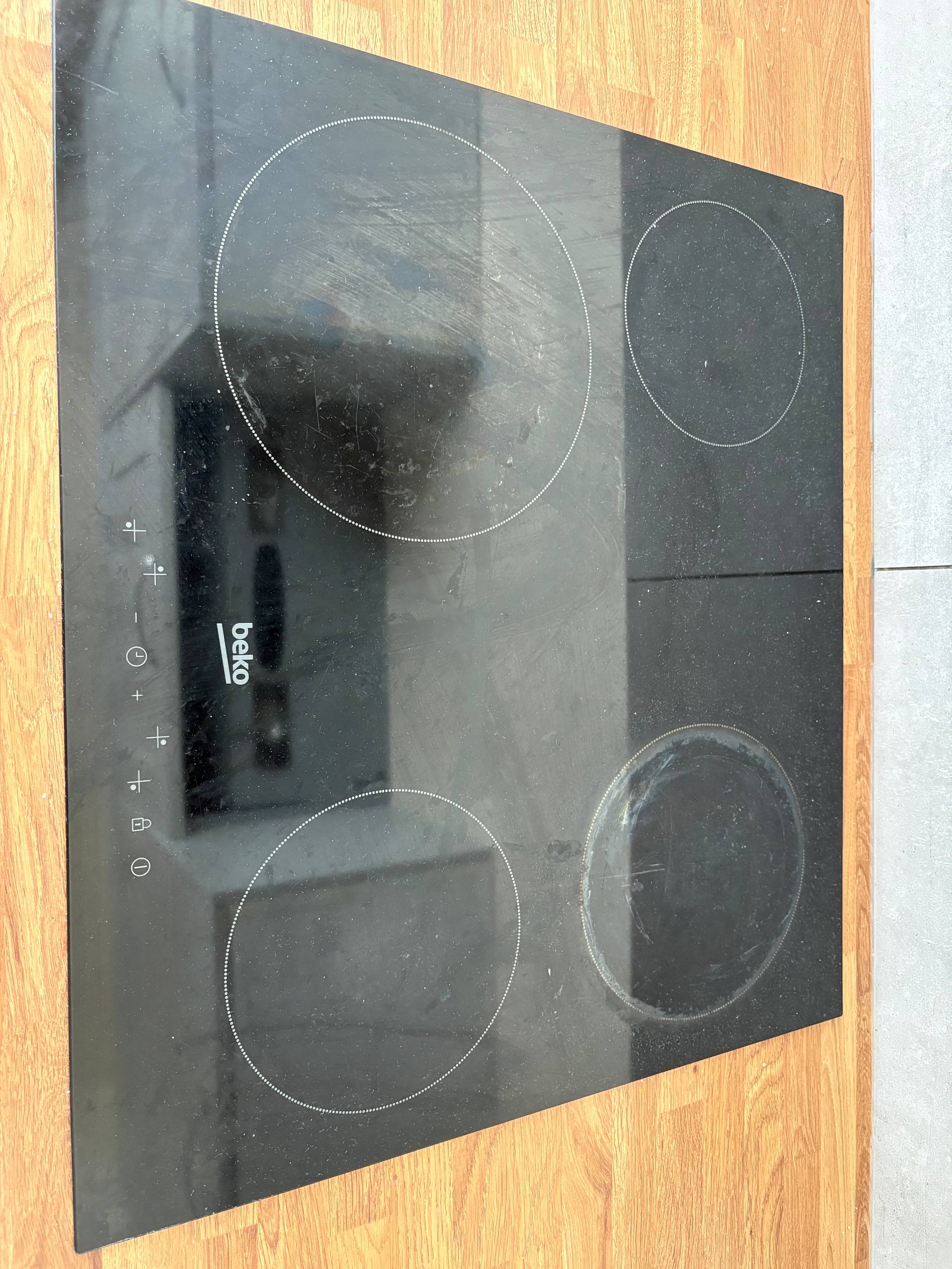 Induction hob before cleaning, with visible marks across the glass surface