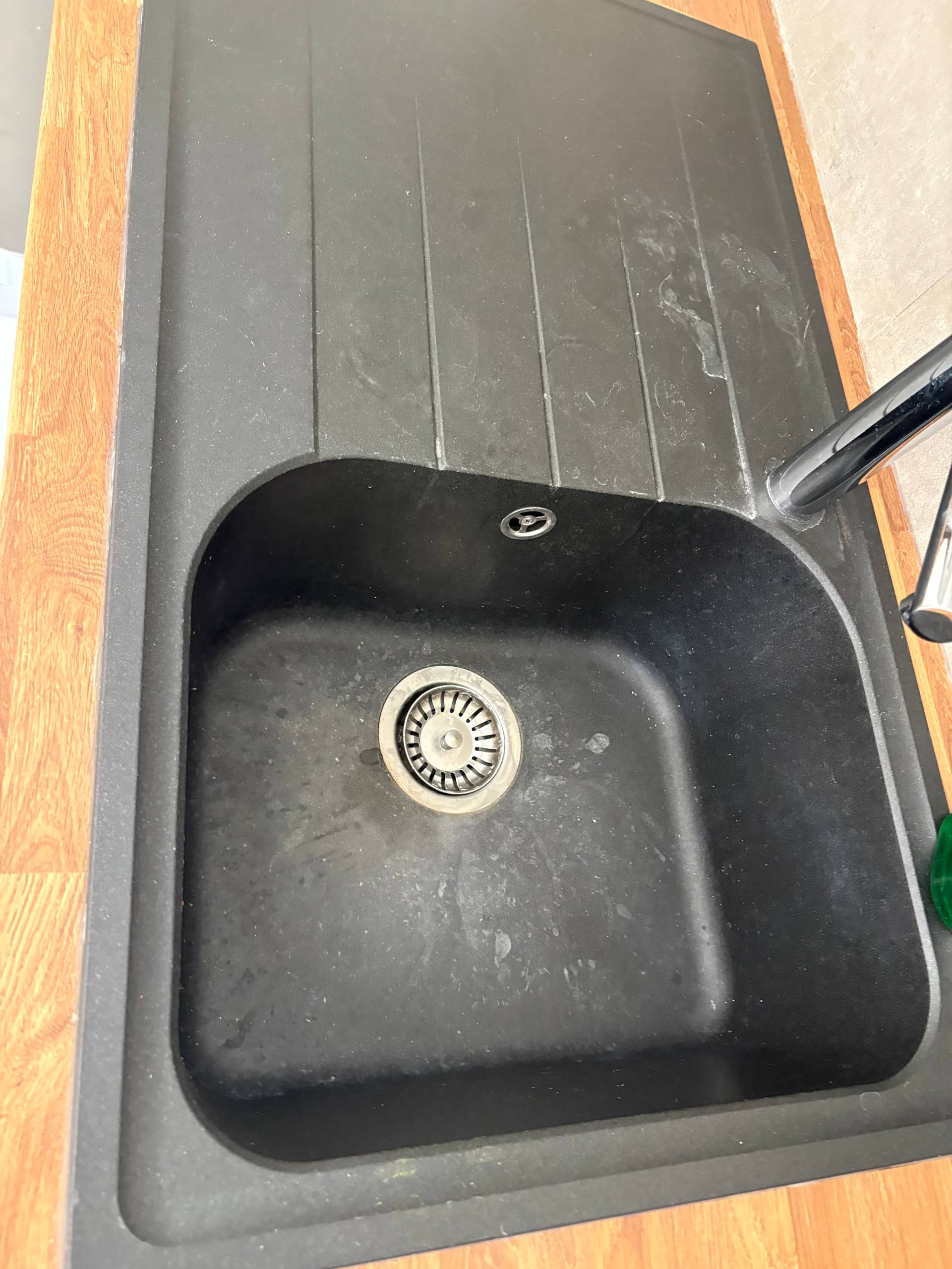 Black kitchen sink and drainer during an end of tenancy clean