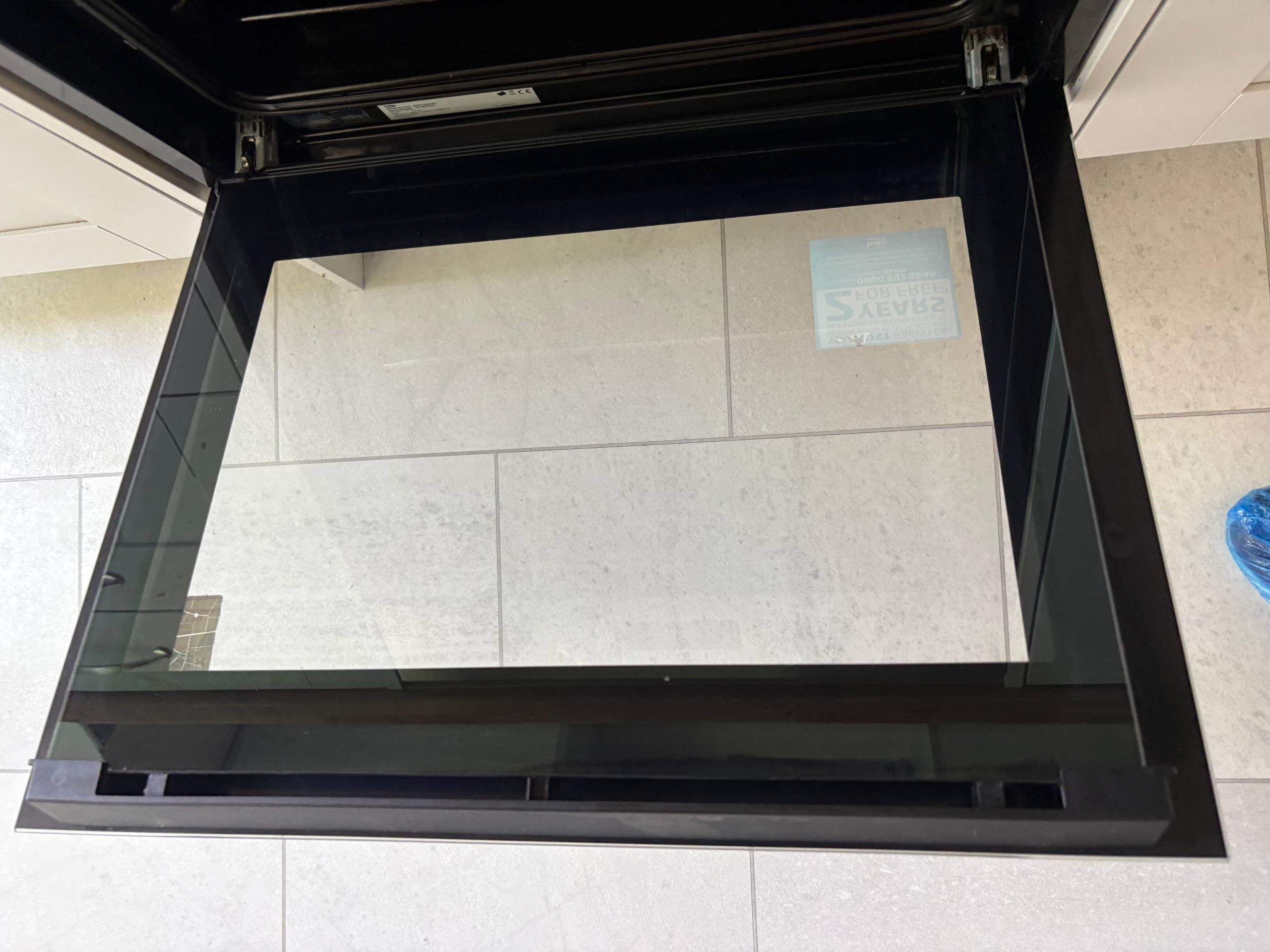 Open oven door and inner glass photographed after cleaning