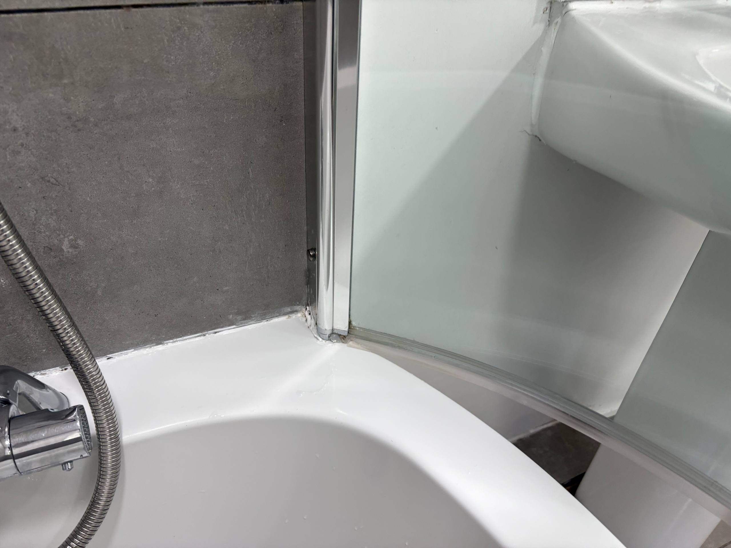 Bath corner and shower screen frame photographed after cleaning