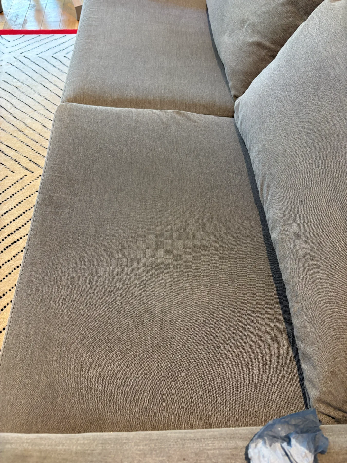 The same seat cushion after hot-water extraction, the rings and dark patches gone and the colour even across the cushion
